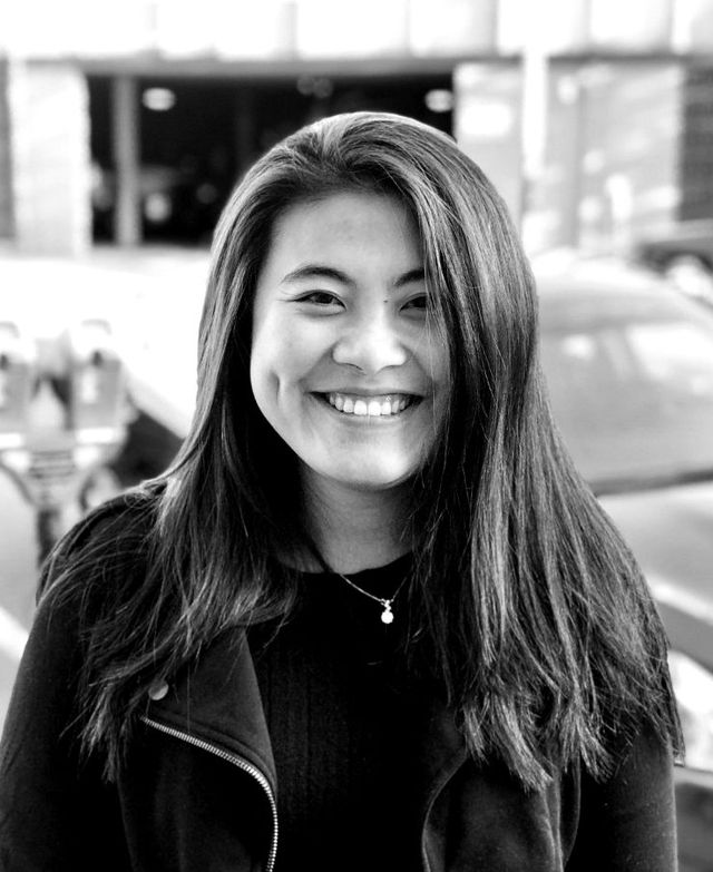 Mila Fang sorrindo, retrato de rua, em preto e branco